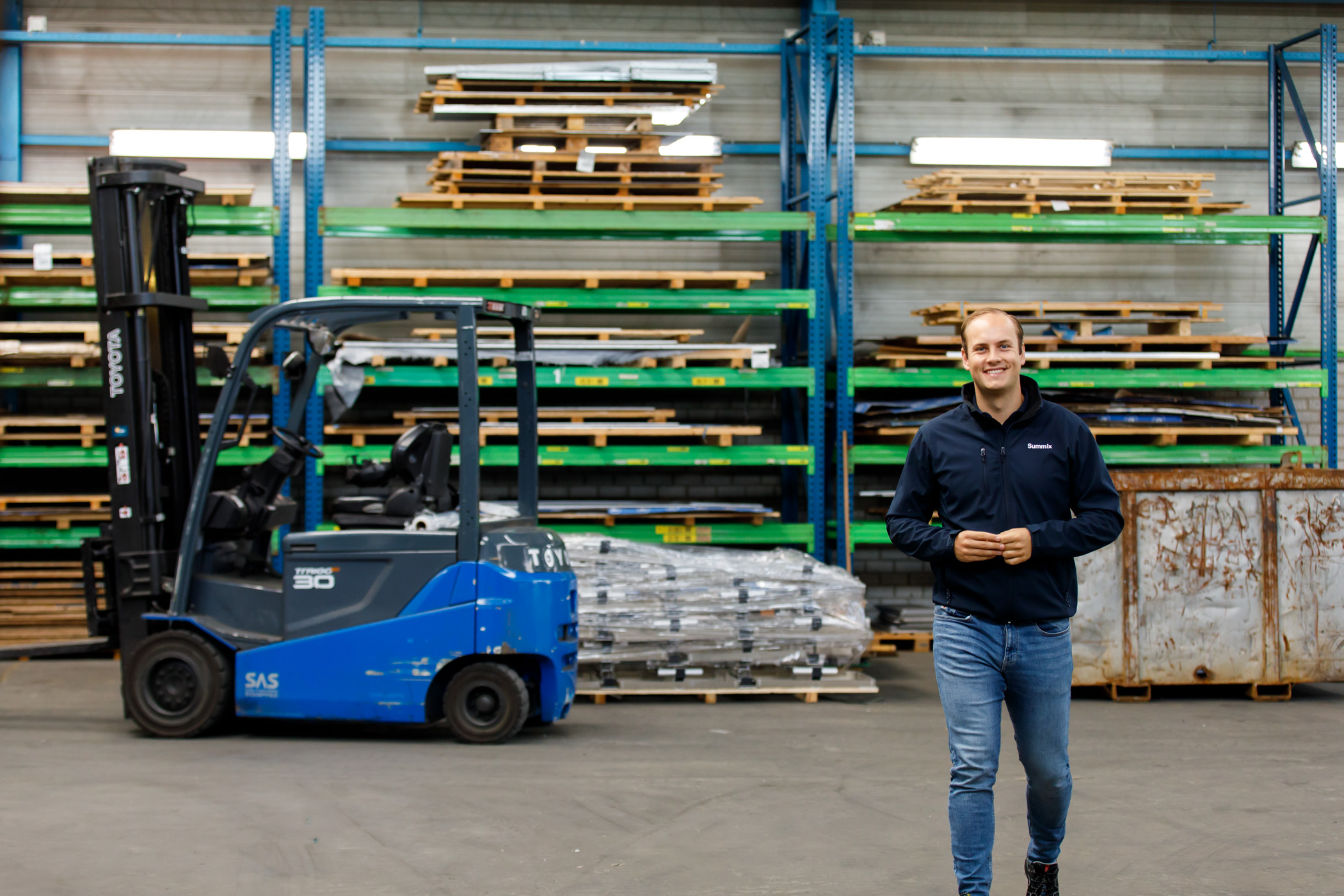 Summix-collega loopt door de productiehal langs een heftruck en materiaalrekken