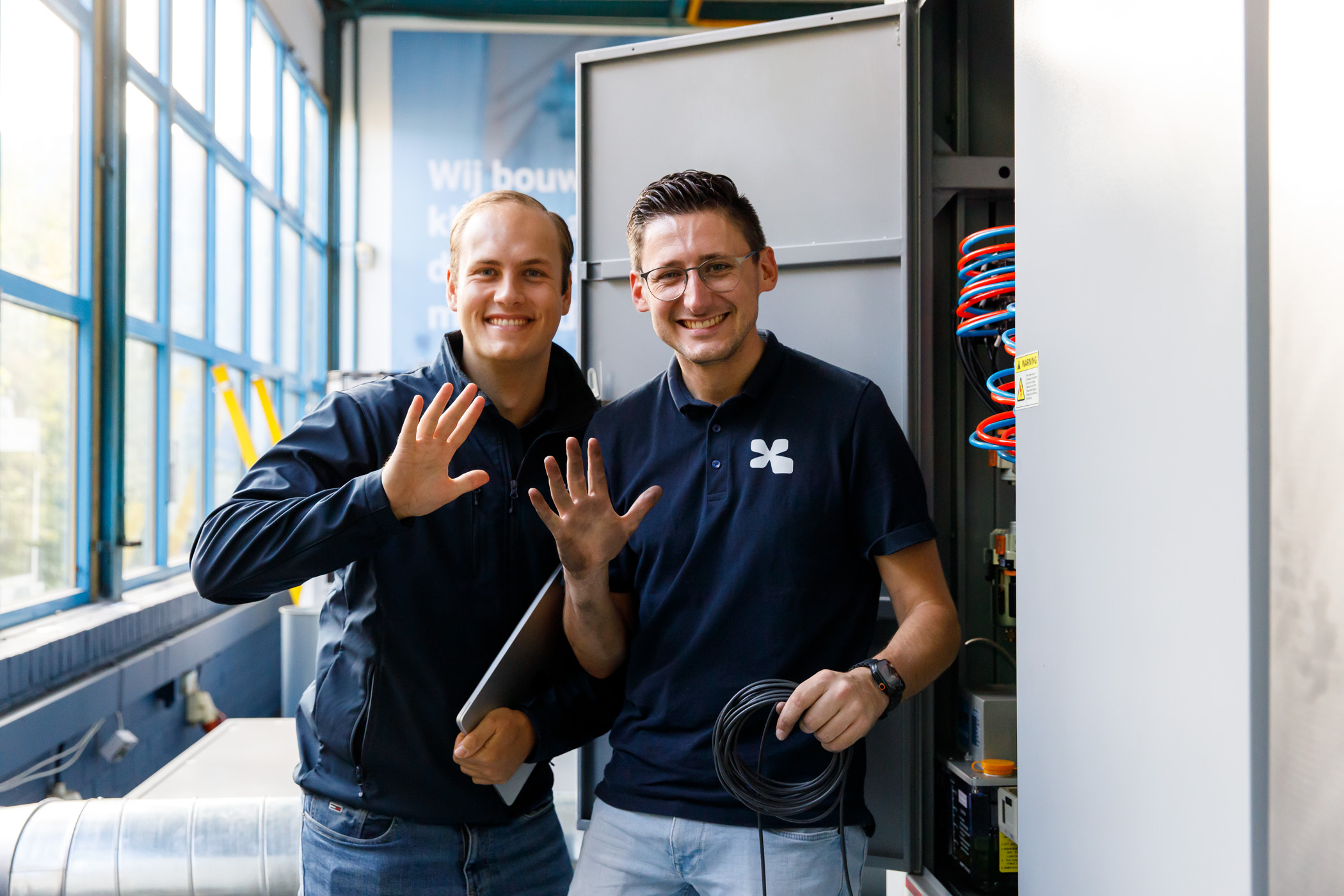 Twee Summix-collega's bij een schakelkast in de productiehal